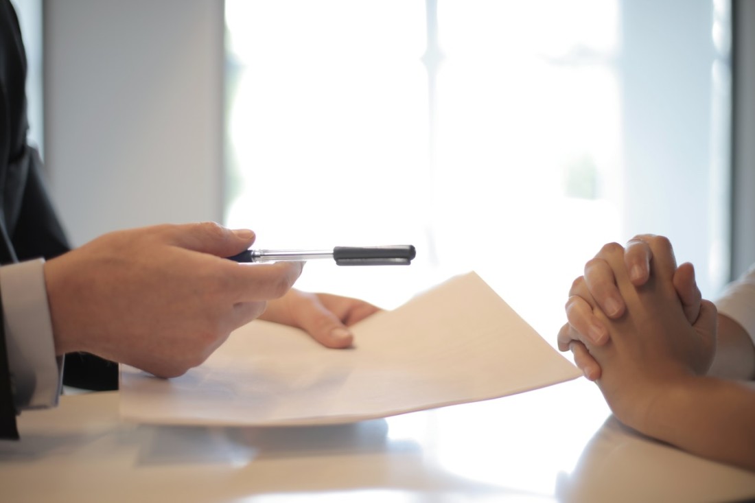 Hands signing a contract