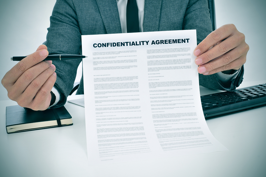 a young man showing a confidentiality agreement document