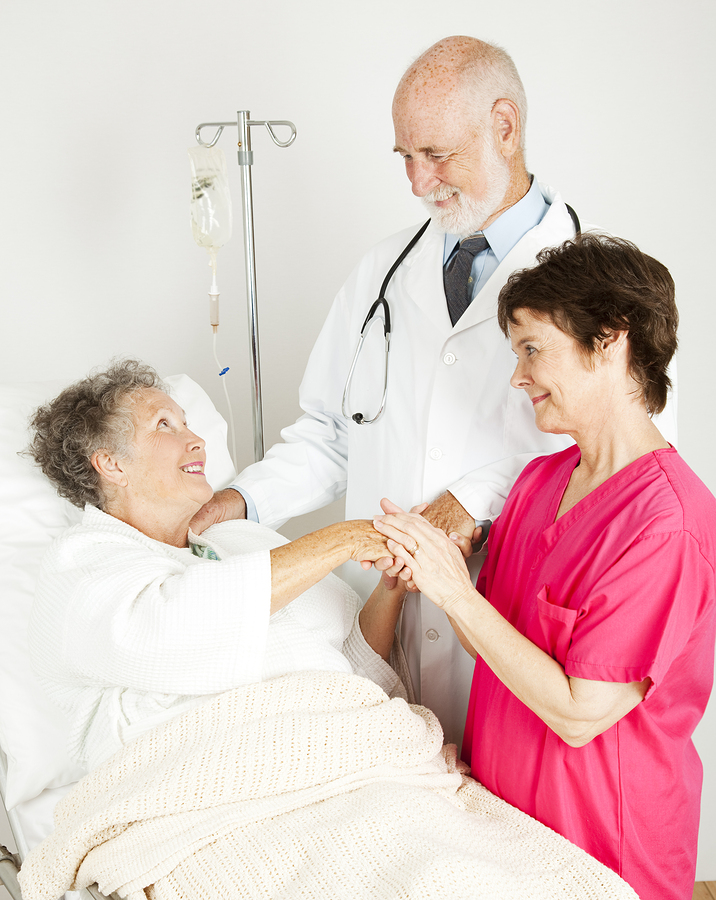 Attentive doctor and nurse caring for an elderly hospital patien