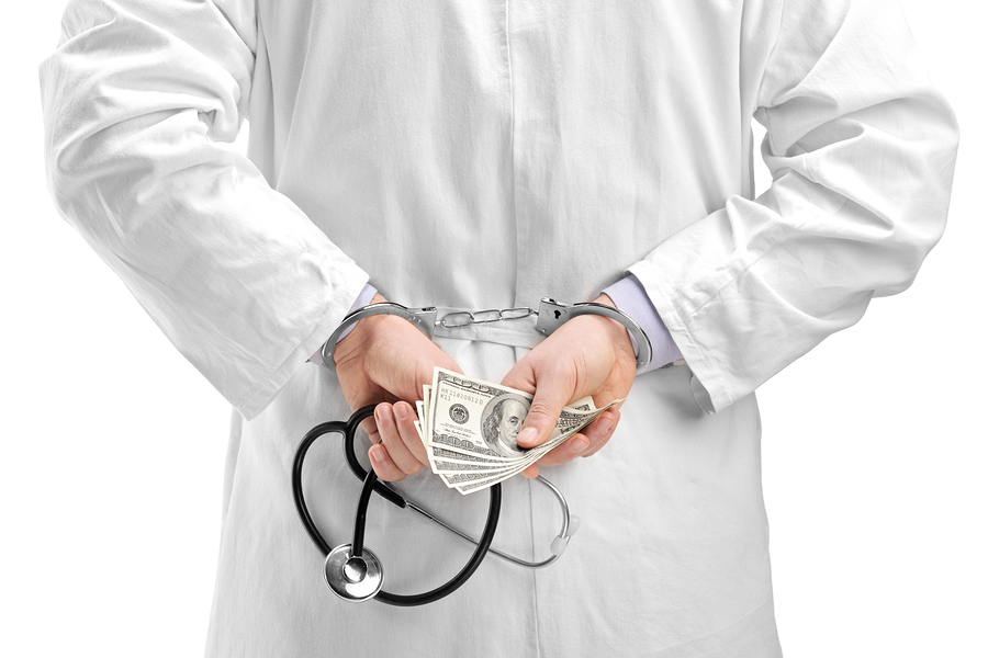A studio shot of a doctor with dollar banknotes and handcuffs