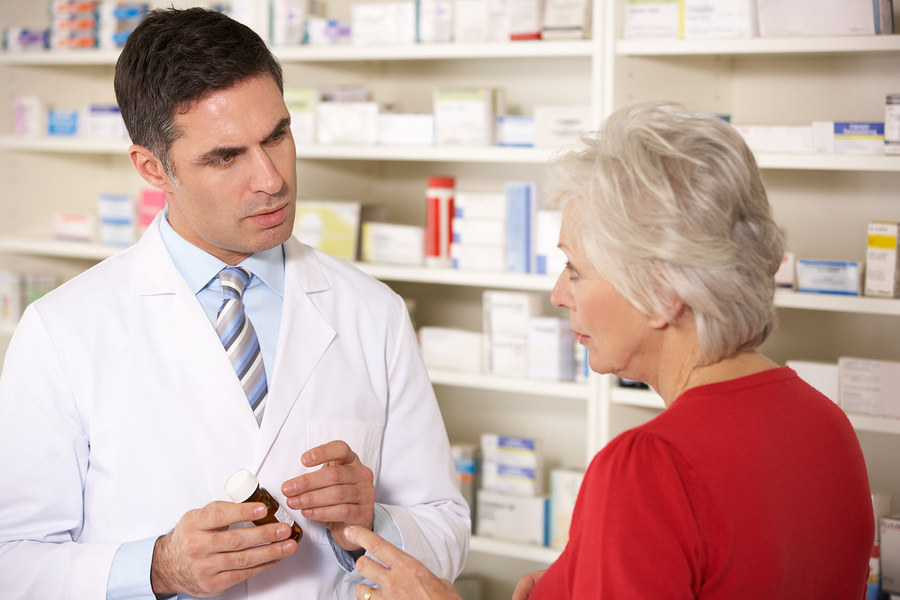 American pharmacist with senior woman in pharmacy