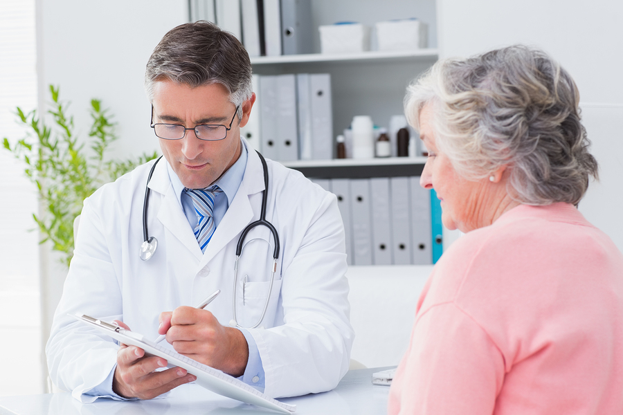 Male doctor explaining prescriptions to senior woman in clinic