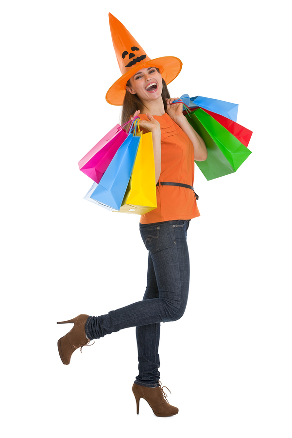 Smiling Young Woman In Halloween Hat With Shopping Bags