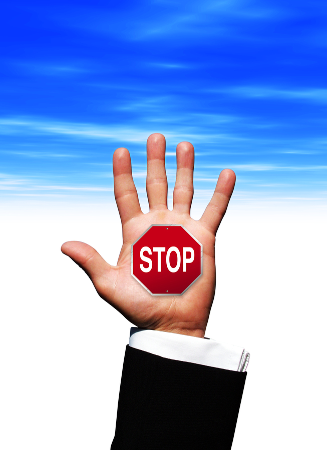 a photo image of a business man's hand with a stop sign ** Note: Slight graininess, best at smaller sizes