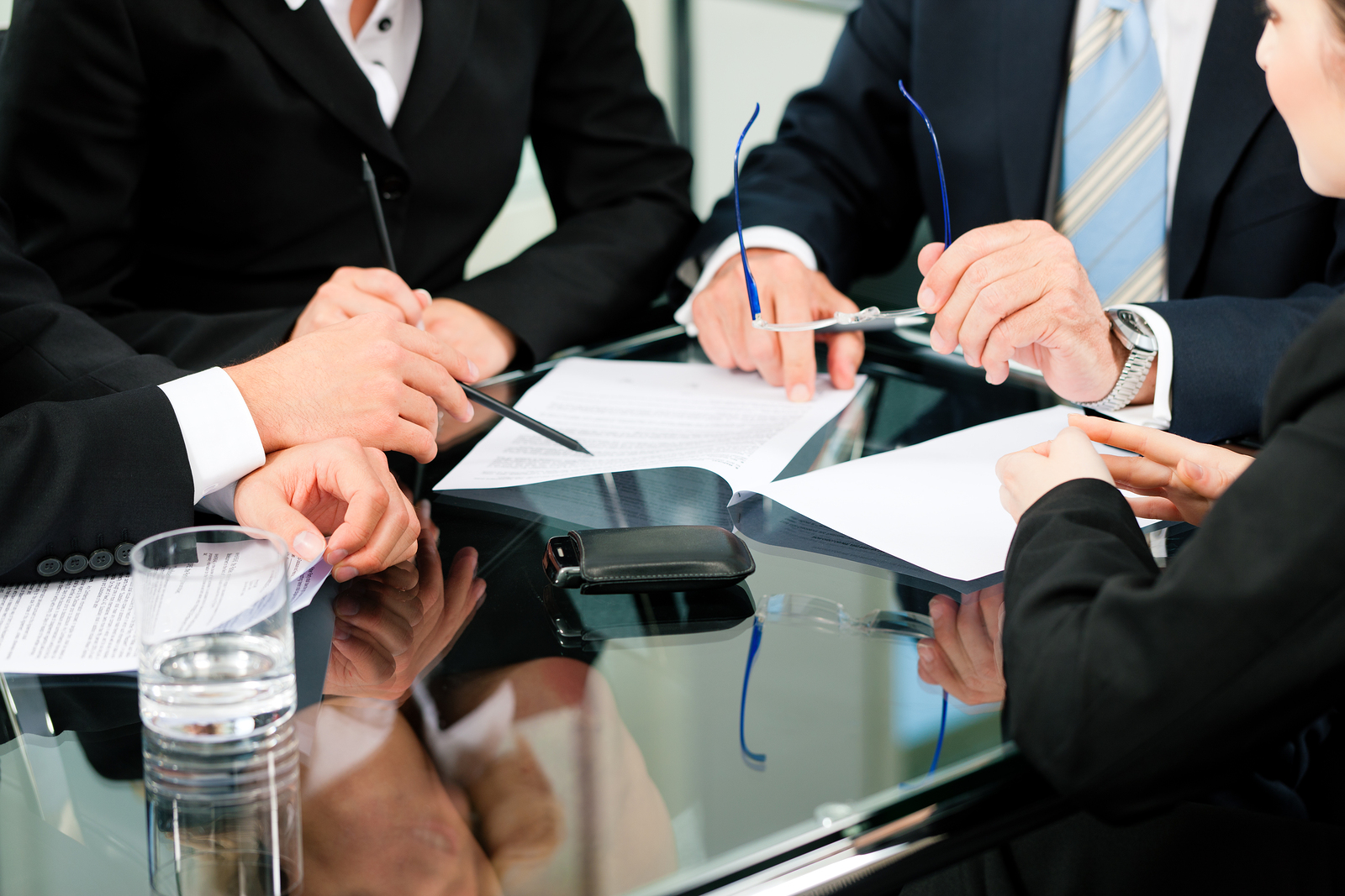 Business - meeting in an office; lawyers or attorneys (only hands) discussing a document or contract agreement